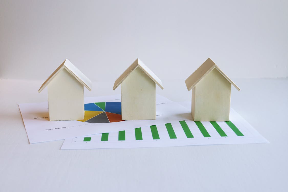 Three wooden model houses and printed graphs