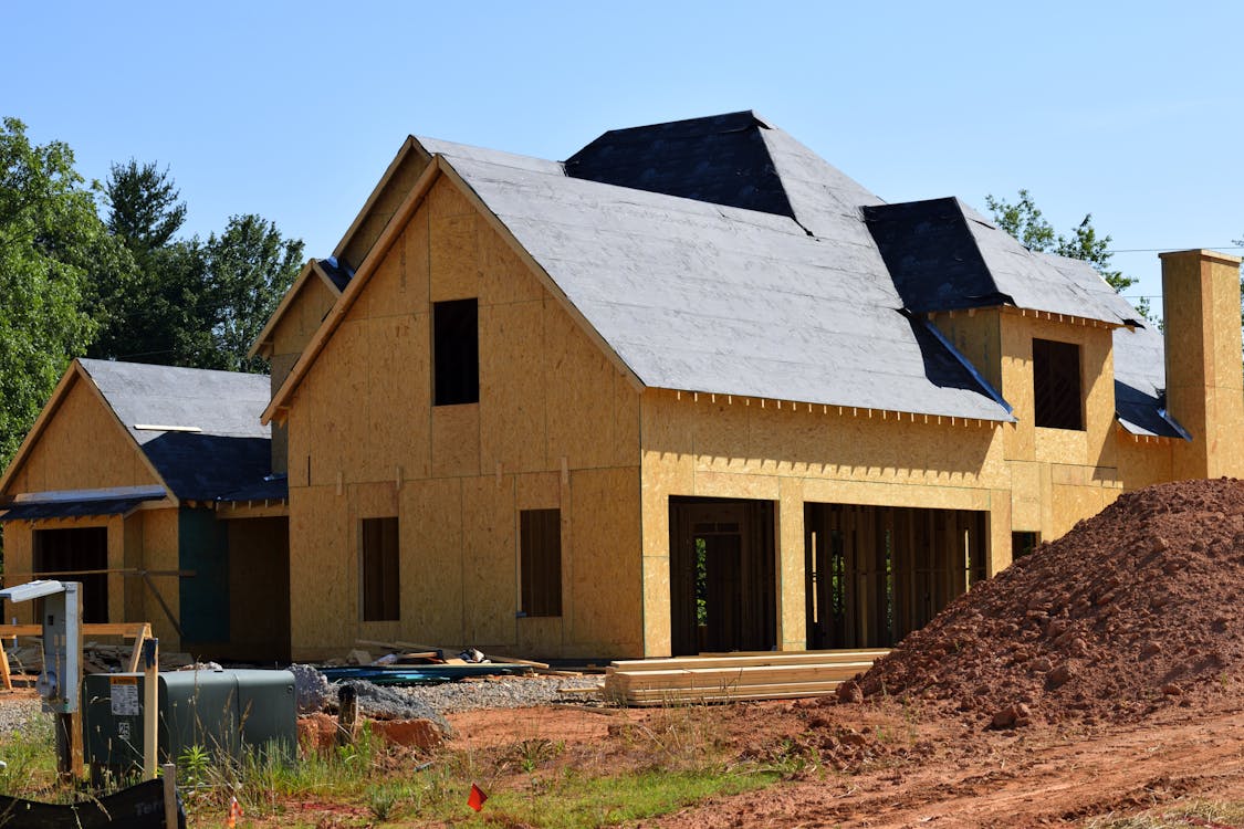 An image of a brown and gray wooden 2-storey house being constructed 