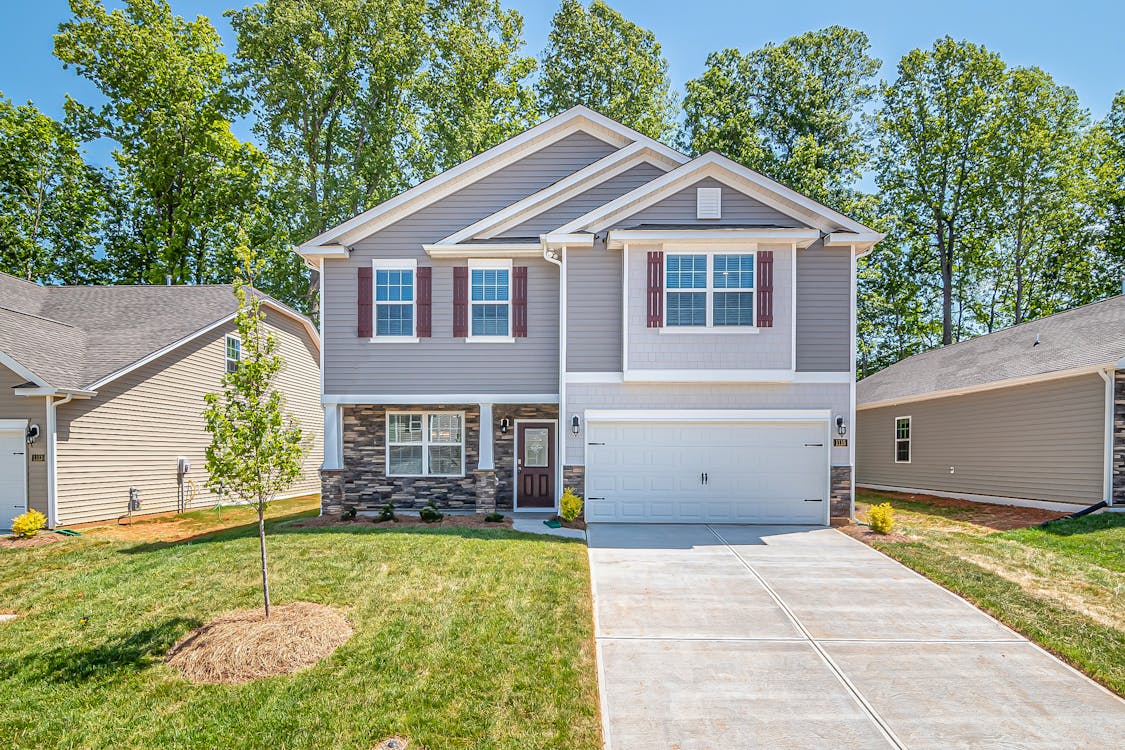 A gray house with a white garage door for rent