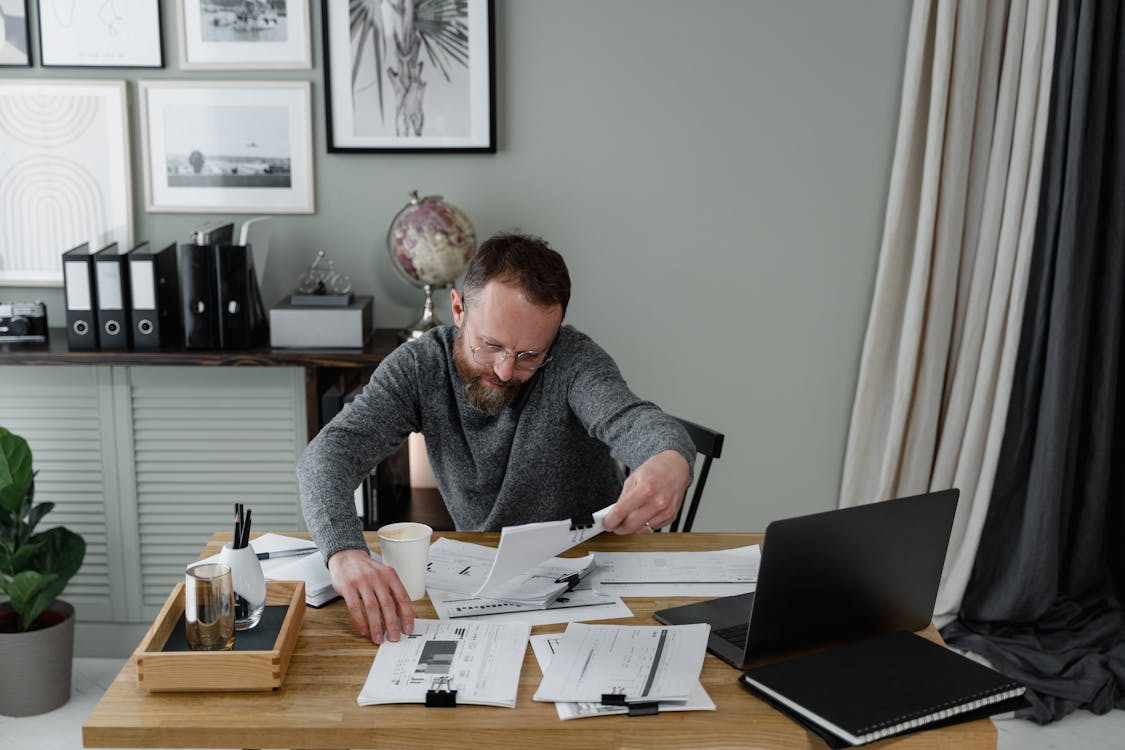 A real estate investor working at a desk, creating a detailed budget for a fix and flip project.