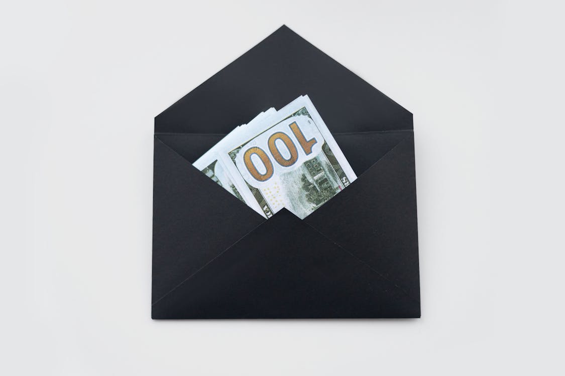 An image of 100 US dollar banknotes in a black envelope