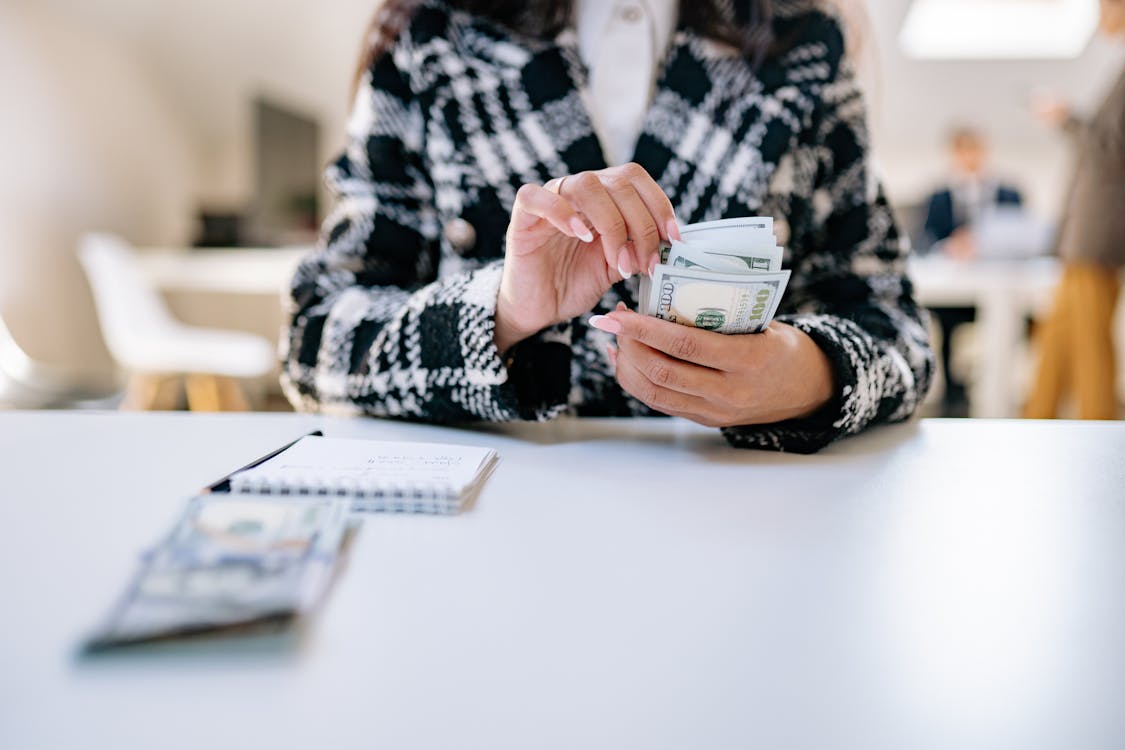 An image of a hard money lender in a black and white blazer counting money