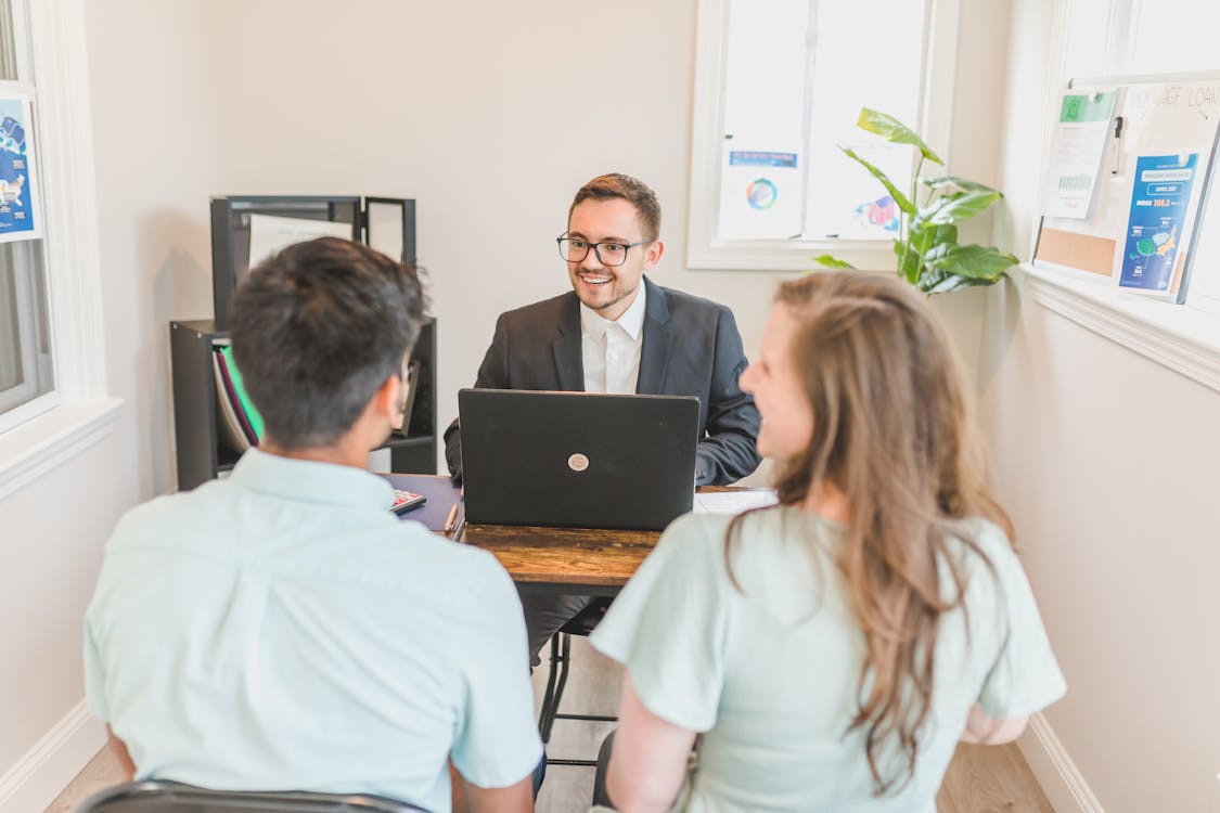 An image of a hard money lender discussing with his clients in his office