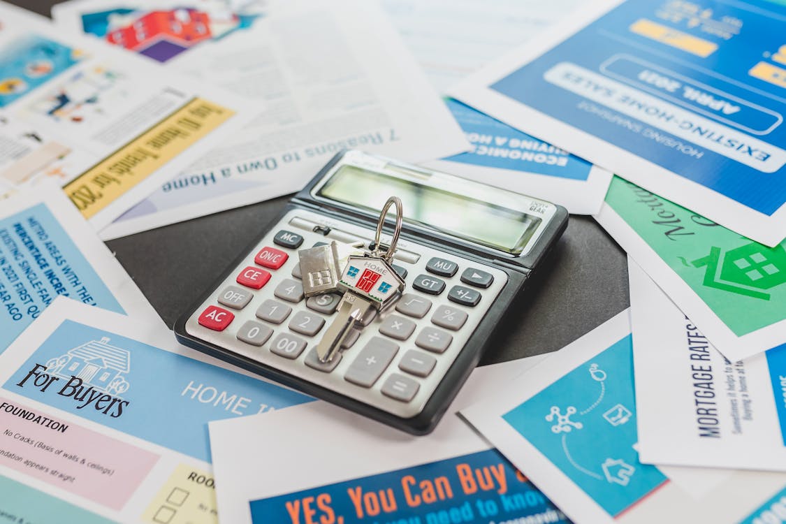 A door key on a calculator surrounded by paper