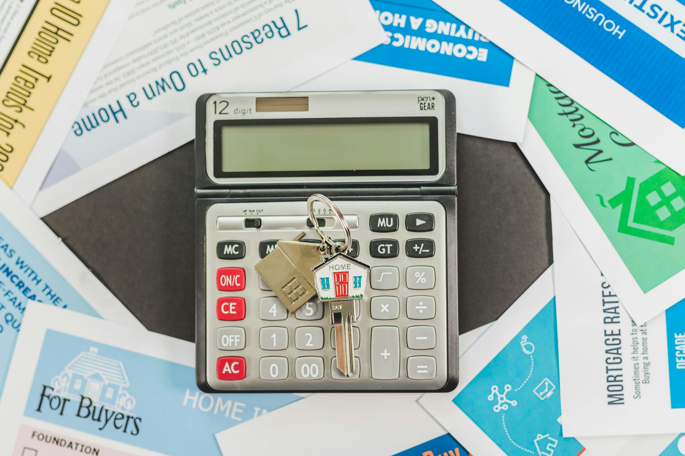 A key with a home keychain on a calculator