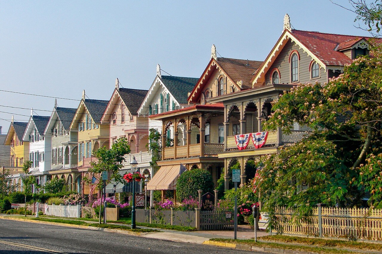 Colorful Victorian-style houses lined up on a suburban street, depicting residential real estate in New Jersey.