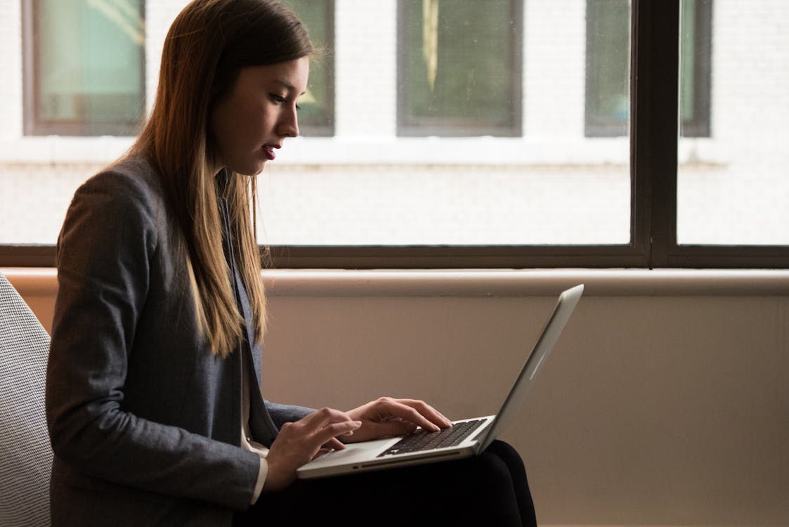 A Woman in a Suit Searching for a Hard Money Lender on Her Laptop