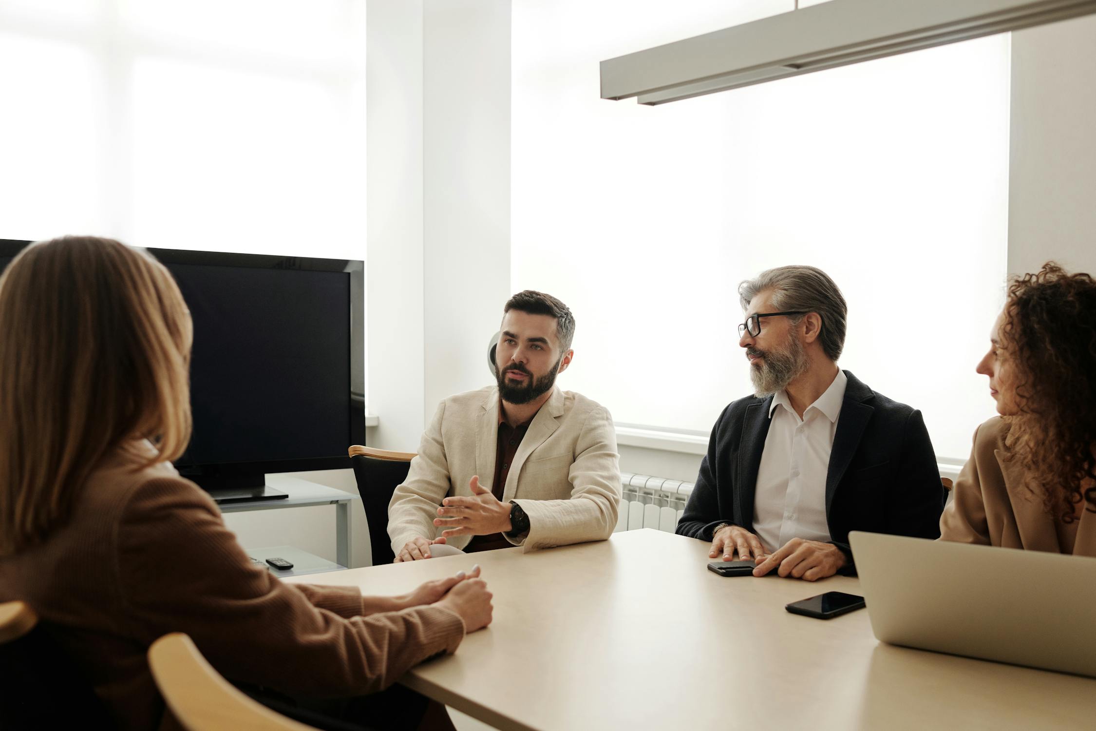 Four individuals engaged in a discussion about real estate financing options.