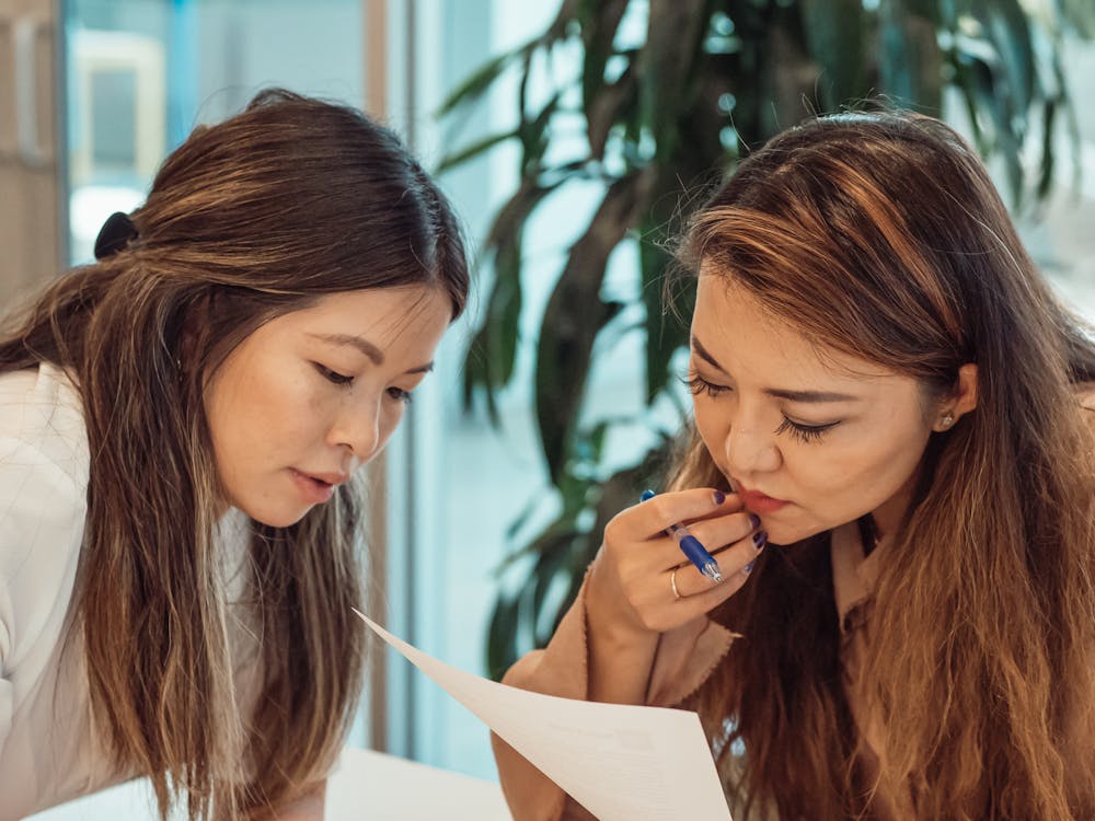 Two investors analyzing a real estate document closely, discussing potential risks and rewards associated with property investment.