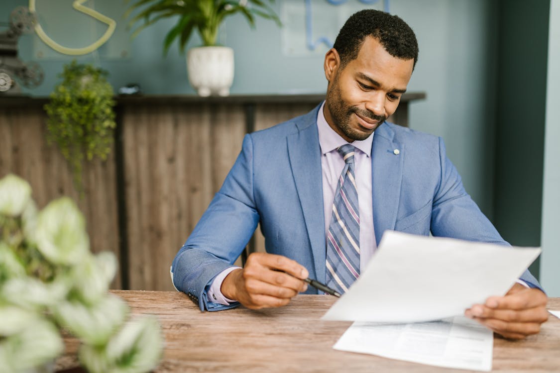 A professional investor in a blue suit examining documents.