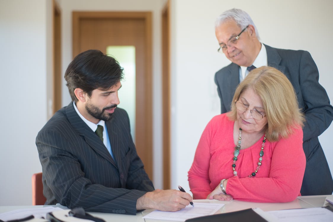 Real estate agent discussing loan documents with clients, highlighting the importance of credit scores in securing financing.