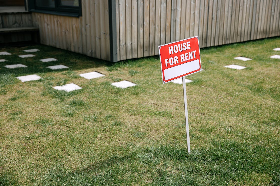 A “House for Rent” sign placed outside a house