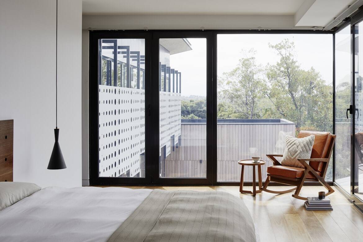 A bedroom with an armchair next to a window