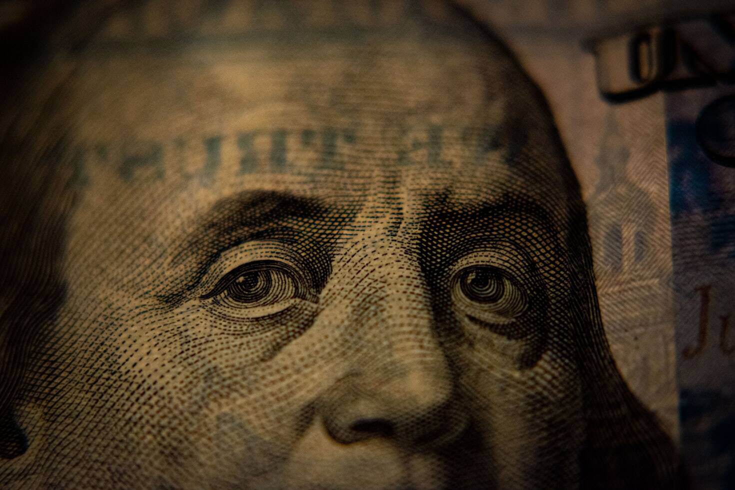 a close-up of a US hundred dollar bill featuring Benjamin Franklin