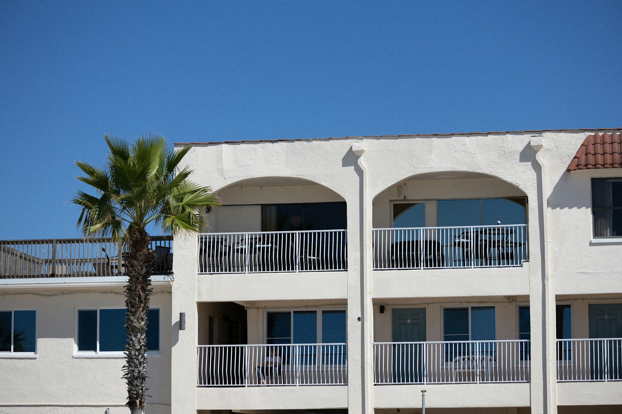 A modern multi-family building against the backdrop of a Florida sunset